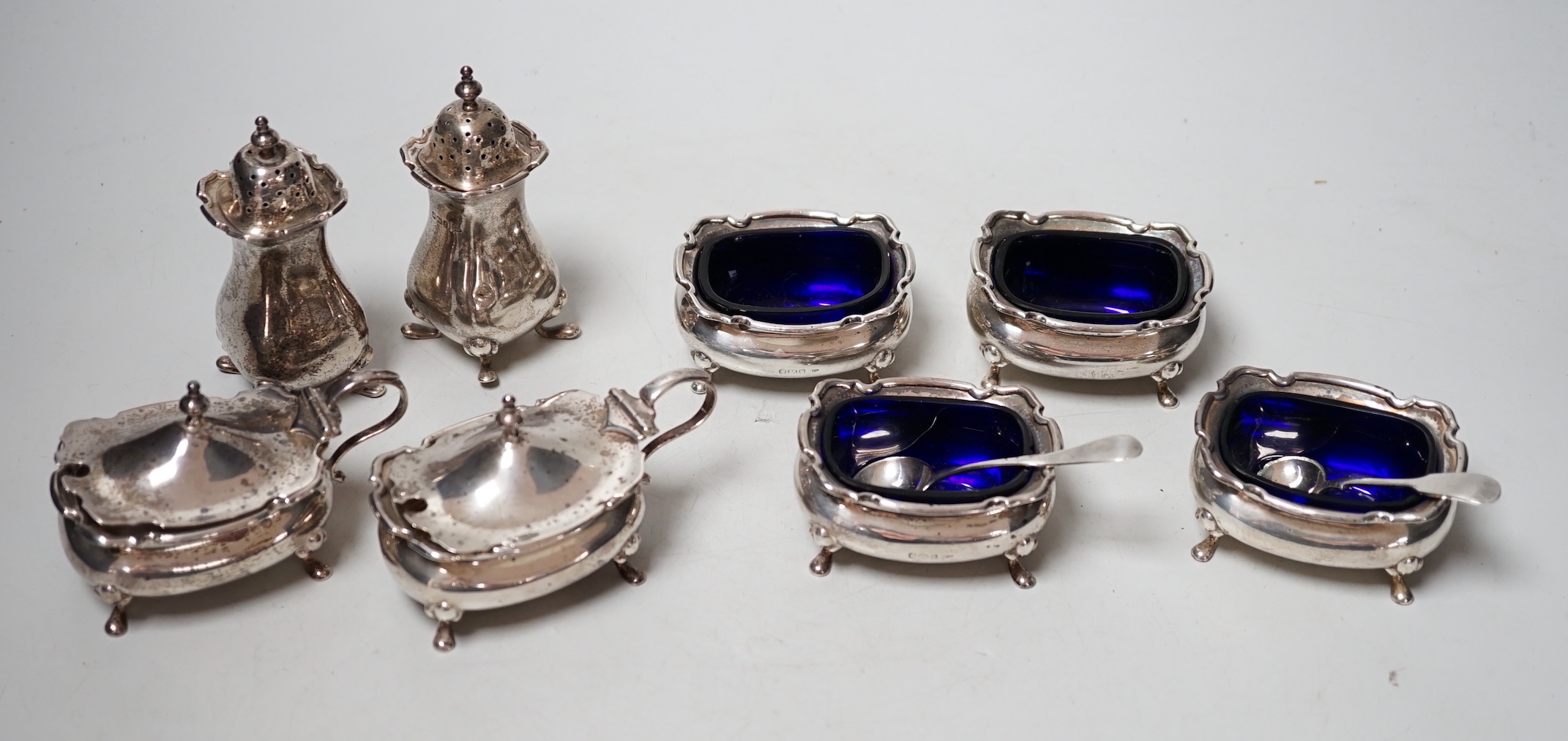 Two four piece silver cruet sets.